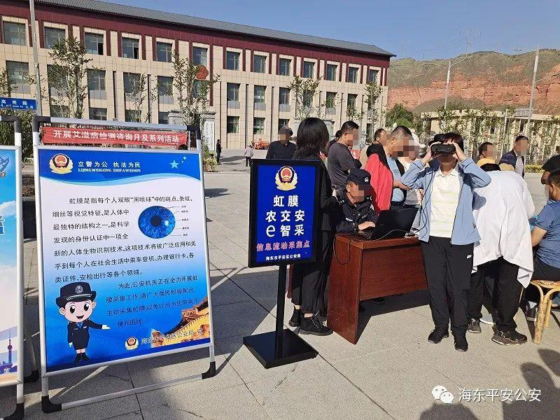 Police collect iris scans next to a sign describing the purpose of iris scan collection. 